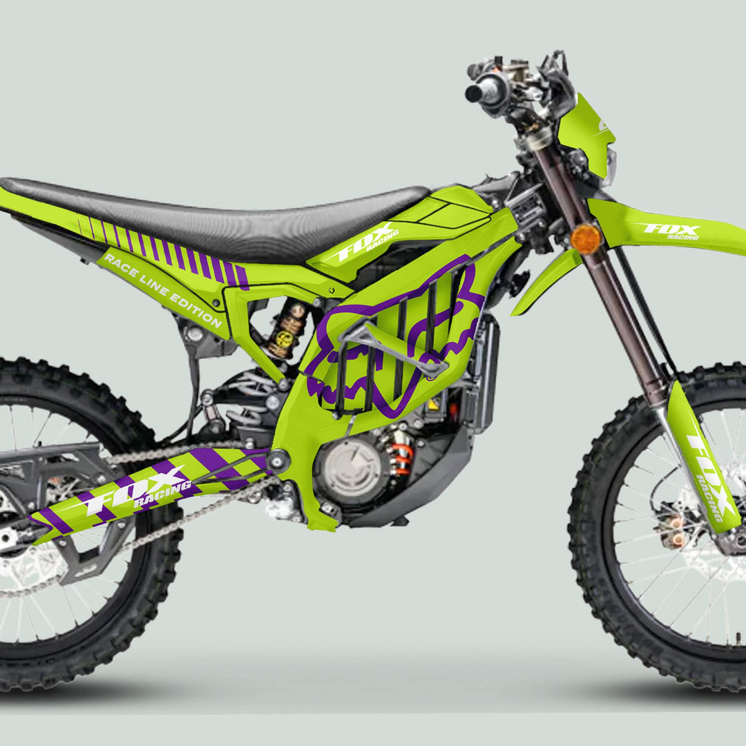 Surron Ultra Bee Graphics Kit FOX RACE LINE Green Purple on a dirt bike, featuring knobby tires, front forks, engine, chain drive, and padded seat.