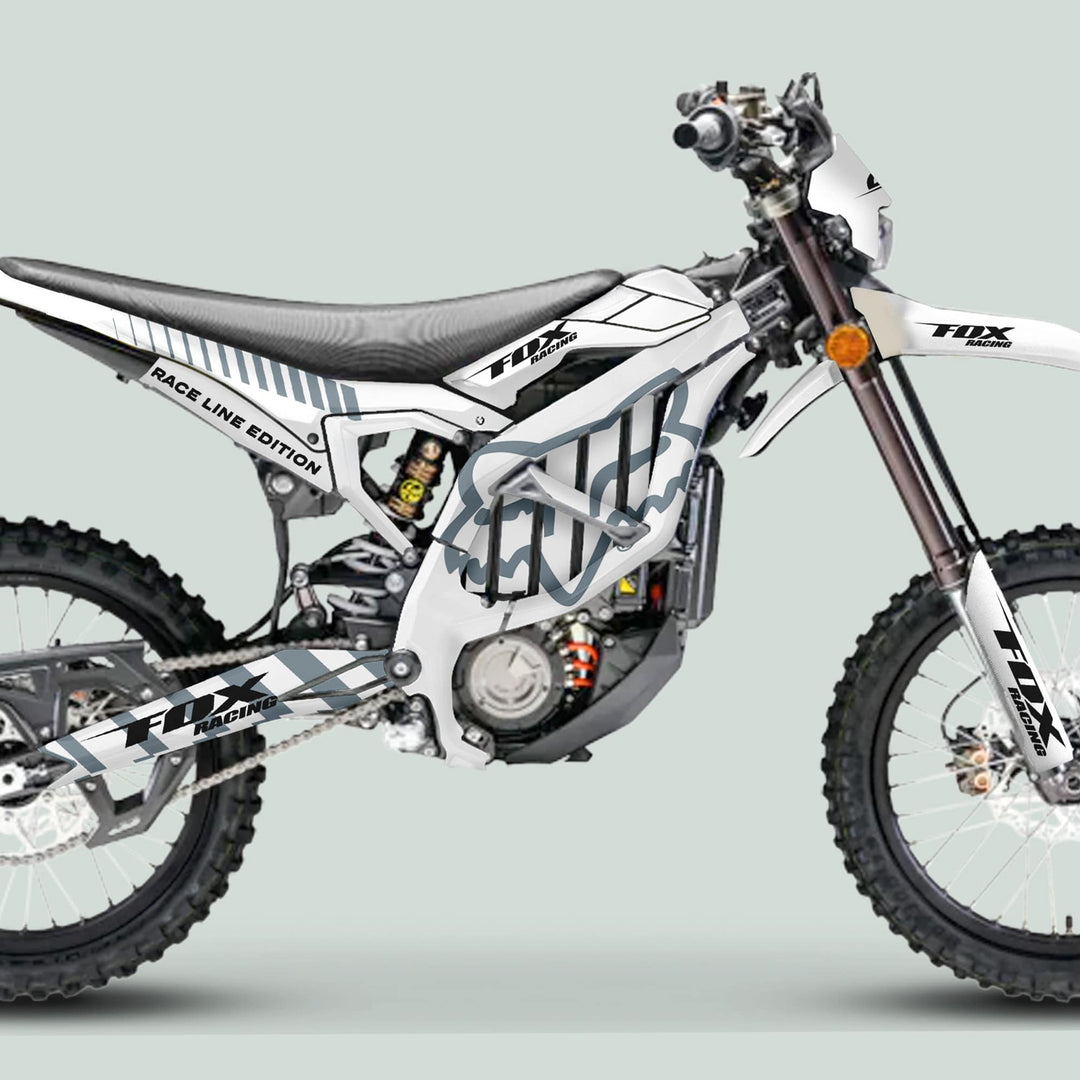 Surron Ultra Bee Graphics Kit FOX RACE LINE White Grey on a dirt bike, showcasing durable, glossy decals perfectly tailored for an enhanced, eye-catching motocross appearance.