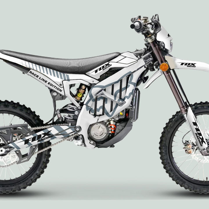 Surron Ultra Bee Graphics Kit FOX RACE LINE White Grey on a dirt bike, showcasing durable, glossy decals perfectly tailored for an enhanced, eye-catching motocross appearance.