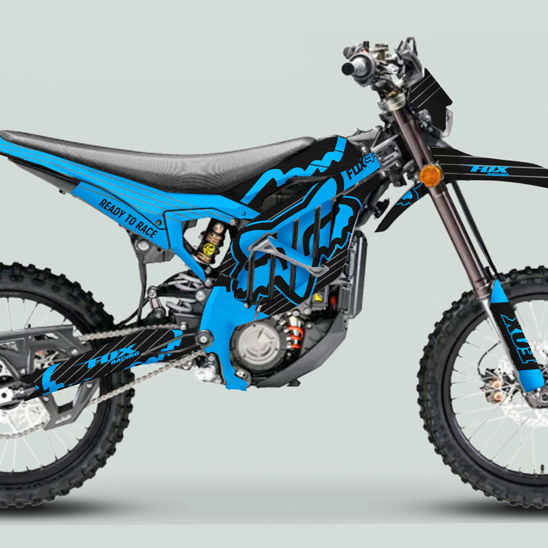 Surron Ultra Bee Graphics Kit FOX STRIPES Black Cyan displayed on a dirt bike, showcasing its frame, engine, knobby tires, and bold Fox Racing graphics.