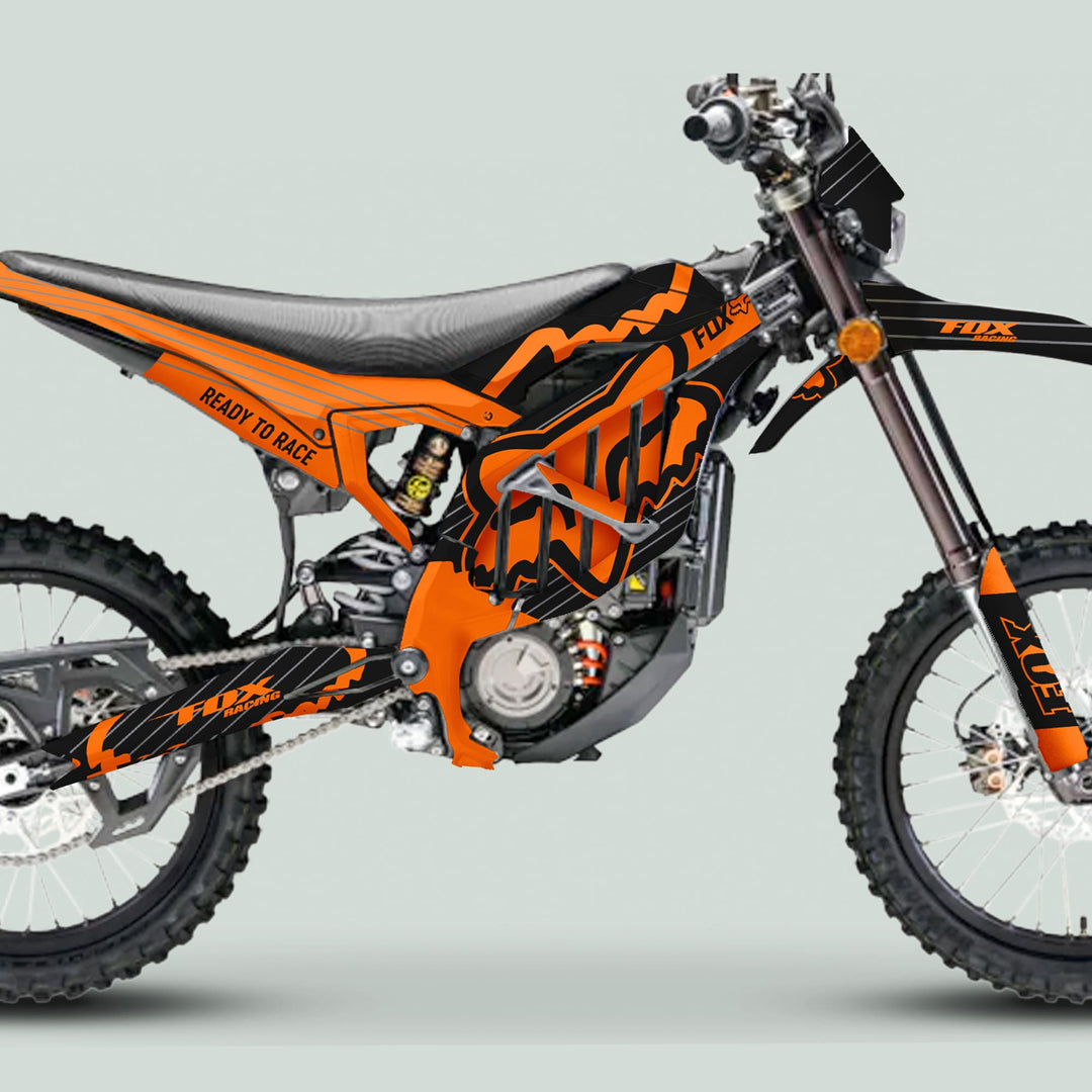 Surron Ultra Bee Graphics Kit FOX STRIPES Black Orange on a dirt bike, showcasing bold Fox Racing graphics, knobby tires, and rugged motocross features.