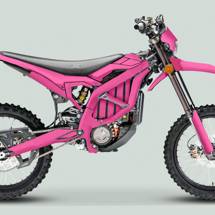 Surron Ultra Bee Graphics Kit SOLID COLOR PINK on a dirt-bike, featuring a vibrant pink design, off-road tires, and minimal street-legal lights for enhanced style and protection.