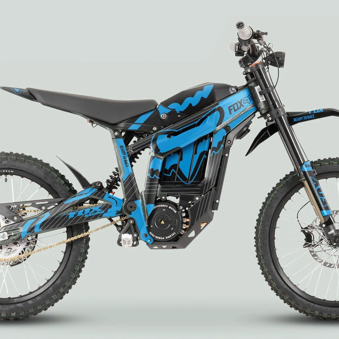 Side profile of an electric dirt bike featuring the Talaria Sting MX3 MX4 Graphics Kit FOX STRIPES Black Cyan, showcasing blue-and-black livery, knobby tires, and central motor housing.