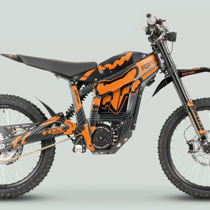 Side-profile of an electric off-road bike featuring the Talaria Sting MX3 MX4 Graphics Kit FOX STRIPES Black Orange, highlighting its durable, vibrant decals and Fox Racing branding.