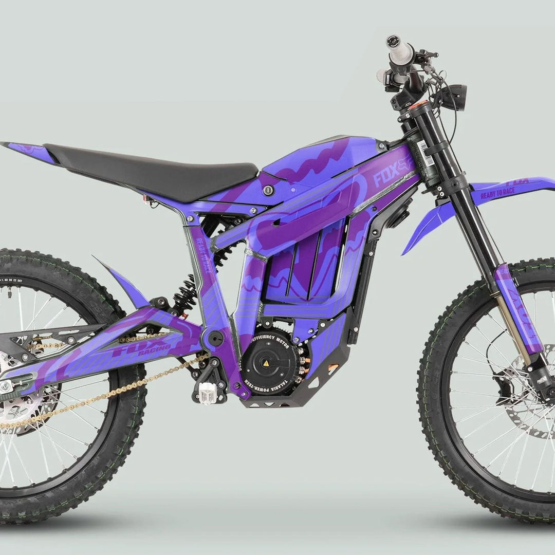 Side view of a purple off-road electric motorcycle with Talaria Sting MX3 MX4 Graphics Kit FOX STRIPES Duo Purple, featuring knobby tires and enclosed electric motor.