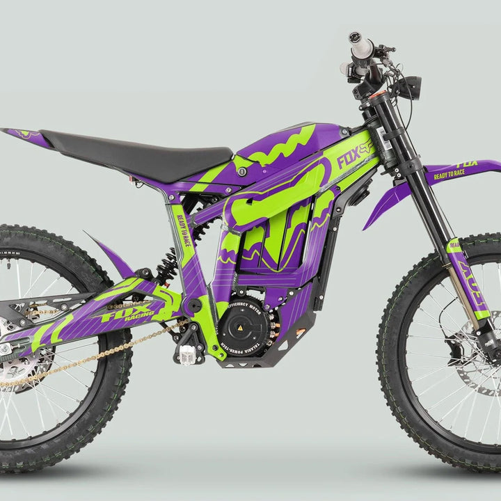 Side profile of a Talaria Sting MX3 MX4 with FOX STRIPES Purple Green graphics, showcasing knobby tires, suspension, mid-mounted motor, and battery pack.