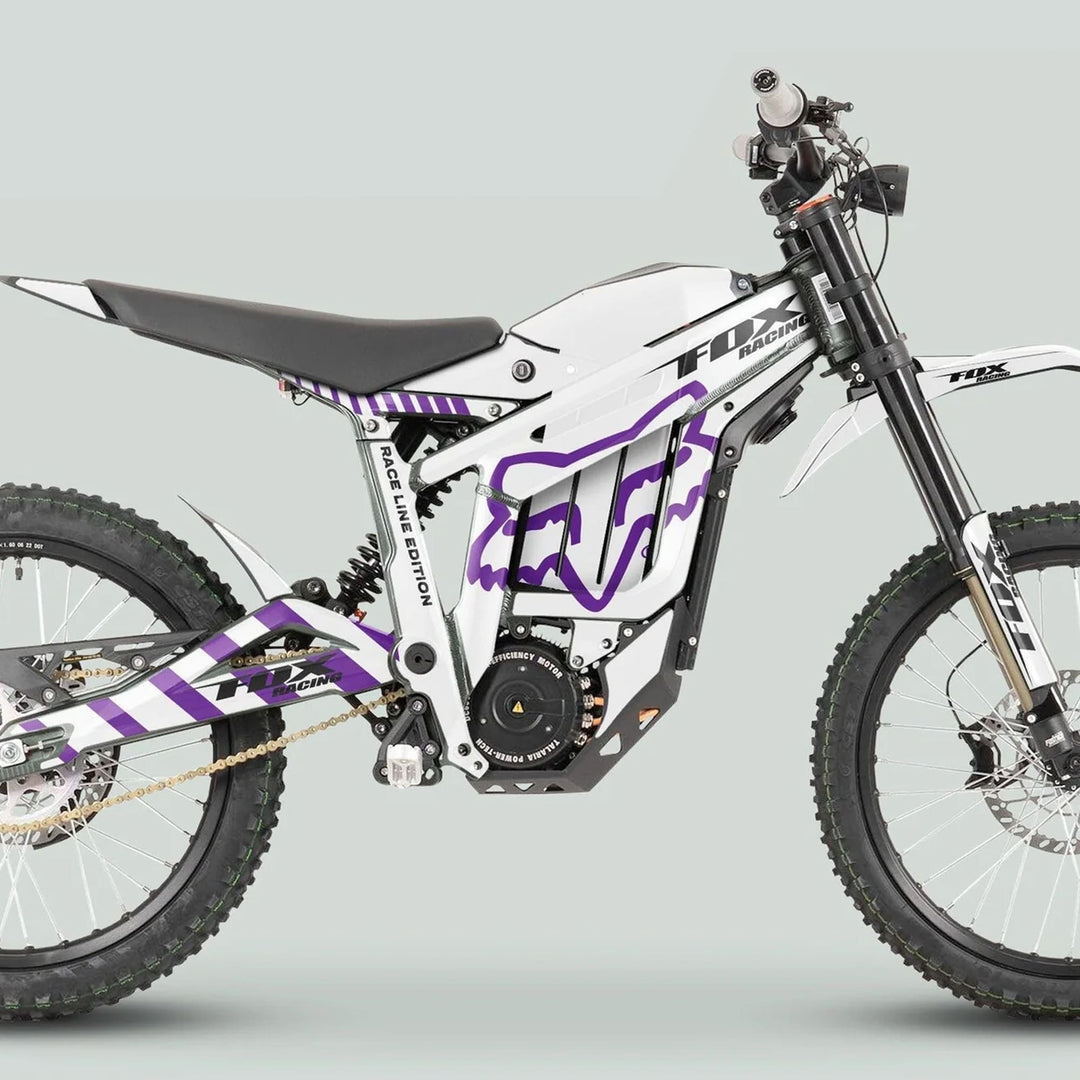 Talaria Sting MX3 MX4 Graphics Kit FOX Raceline White Purple on electric dirt bike, showcasing knobby tires, long-travel forks, and purple Fox Racing accents.