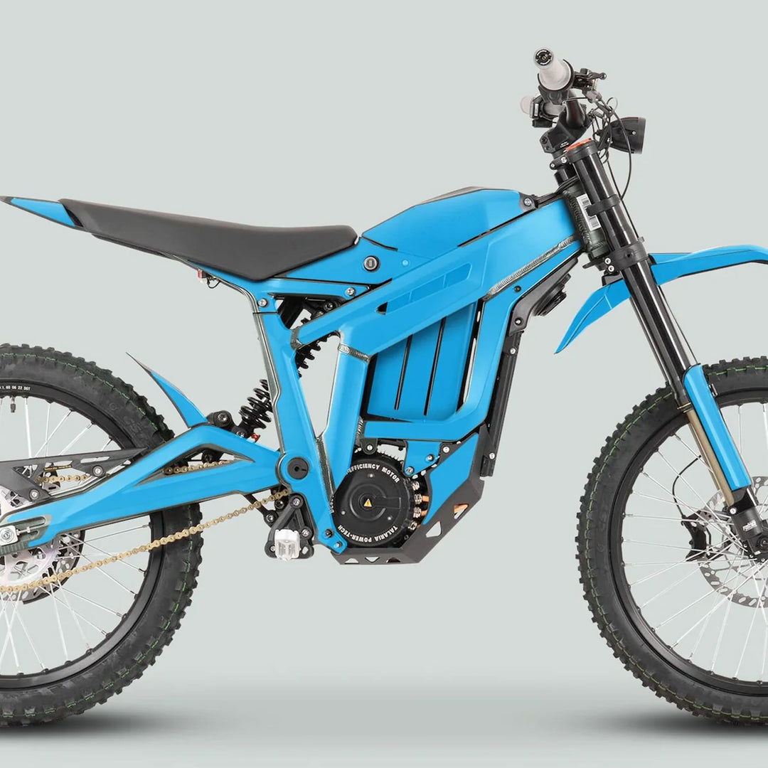 Side view of Talaria Sting MX3 MX4 Graphics Kit SOLID COLOR CYAN on a blue e-dirt bike, showcasing tubular frame, high-efficiency motor, suspension, and knobbly tires.