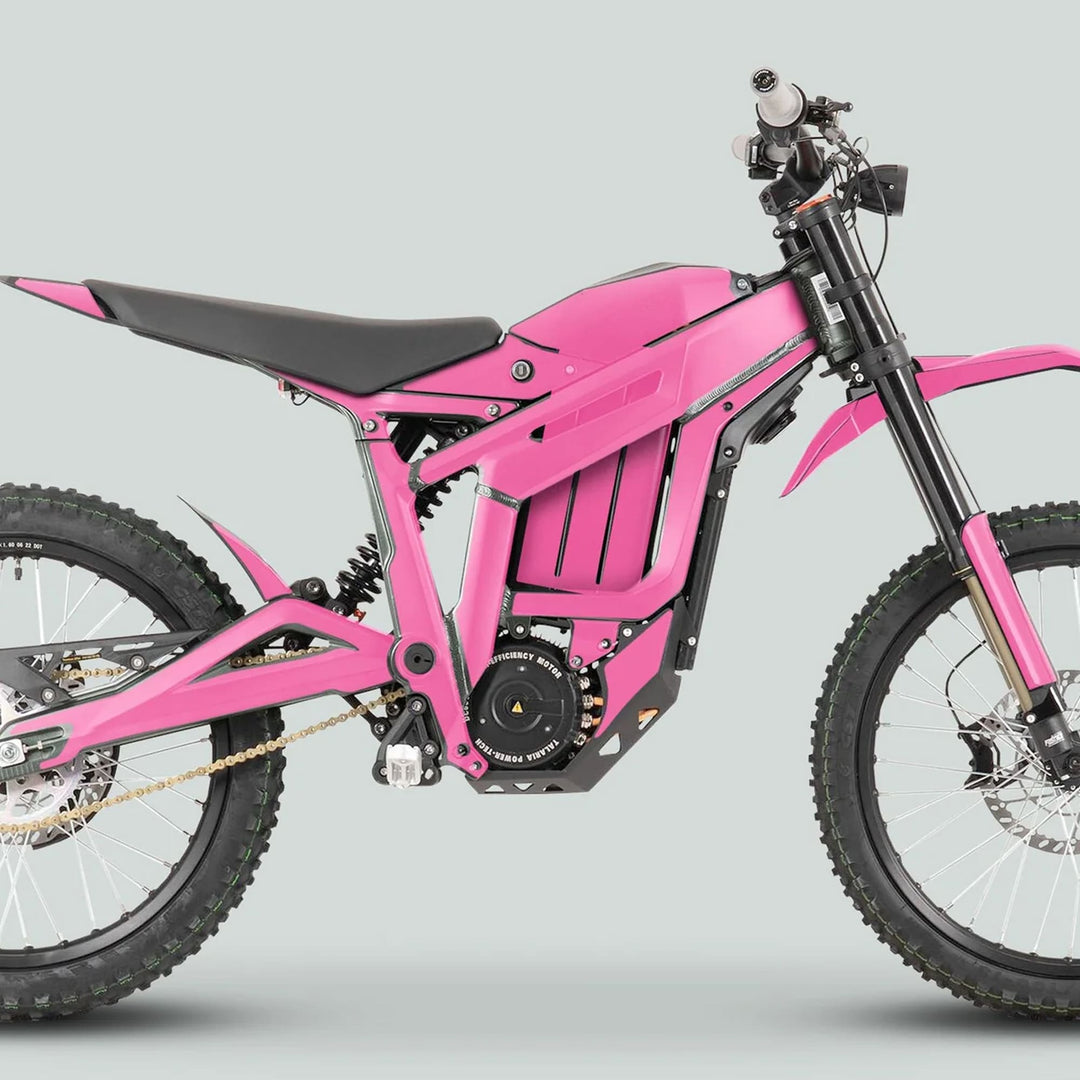 Side view of a Talaria Sting MX3 MX4 Graphics Kit SOLID COLOR PINK on an electric off-road motorcycle, showcasing its knobby tires and central battery housing.