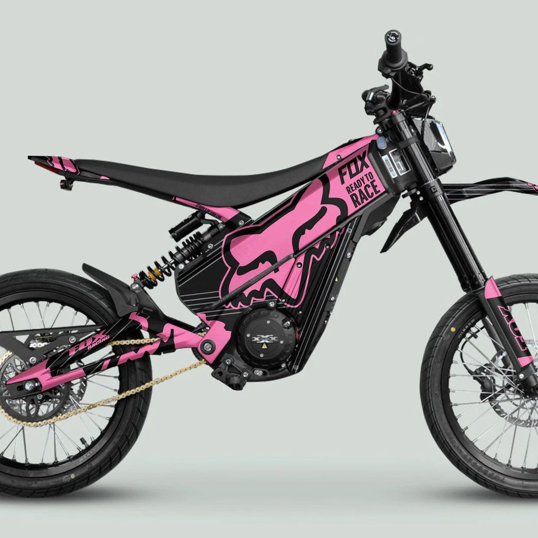 Side view of a Talaria XXX Graphics Kit FOX STRIPES Black Pink on an electric dirt-bike, showcasing its pink and black livery with street-legal tires.