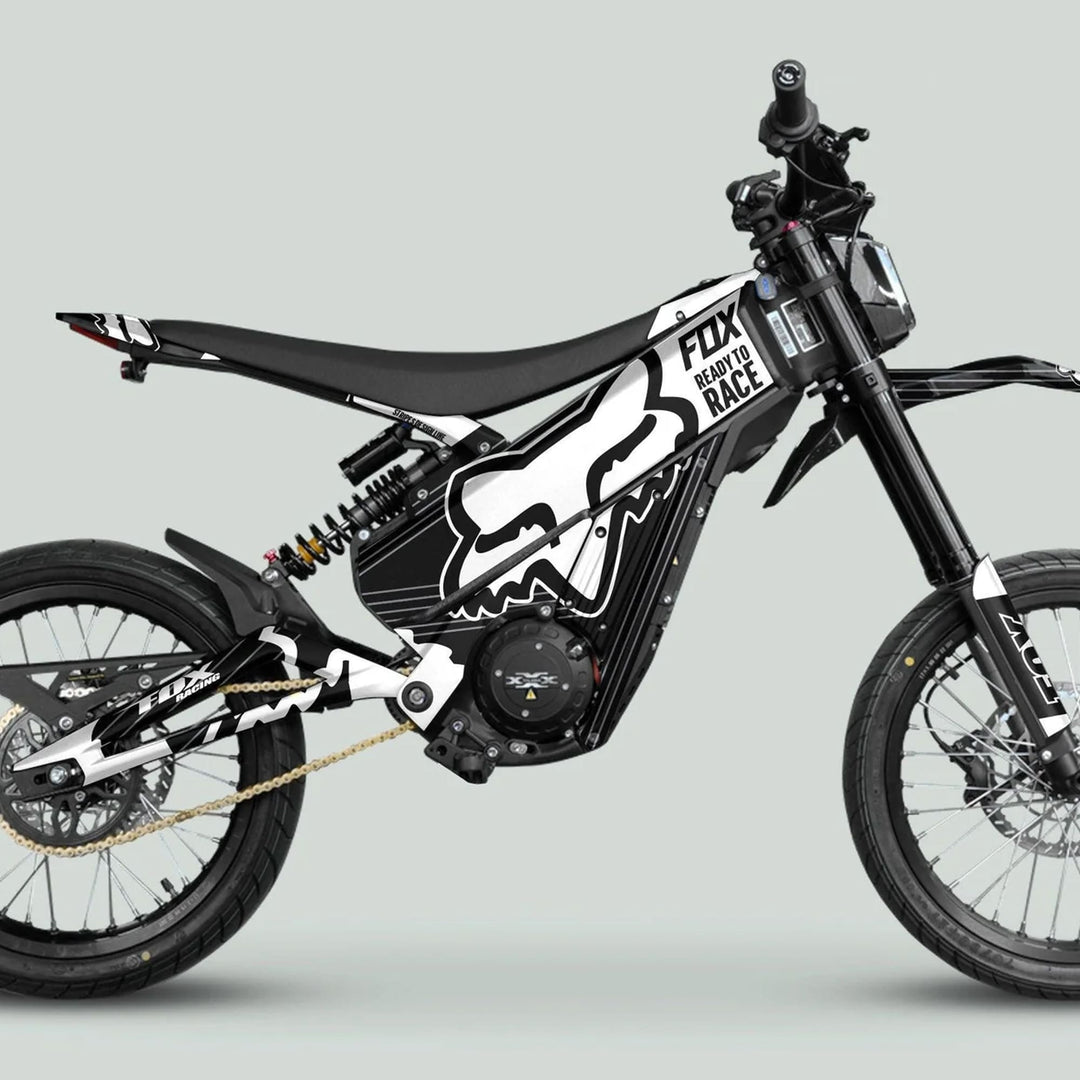 Side-profile of a Talaria e-dirt bike with Talaria XXX Graphics Kit FOX STRIPES, showcasing frame, motor, suspension, and spoked wheels with stylish Fox Racing decals.