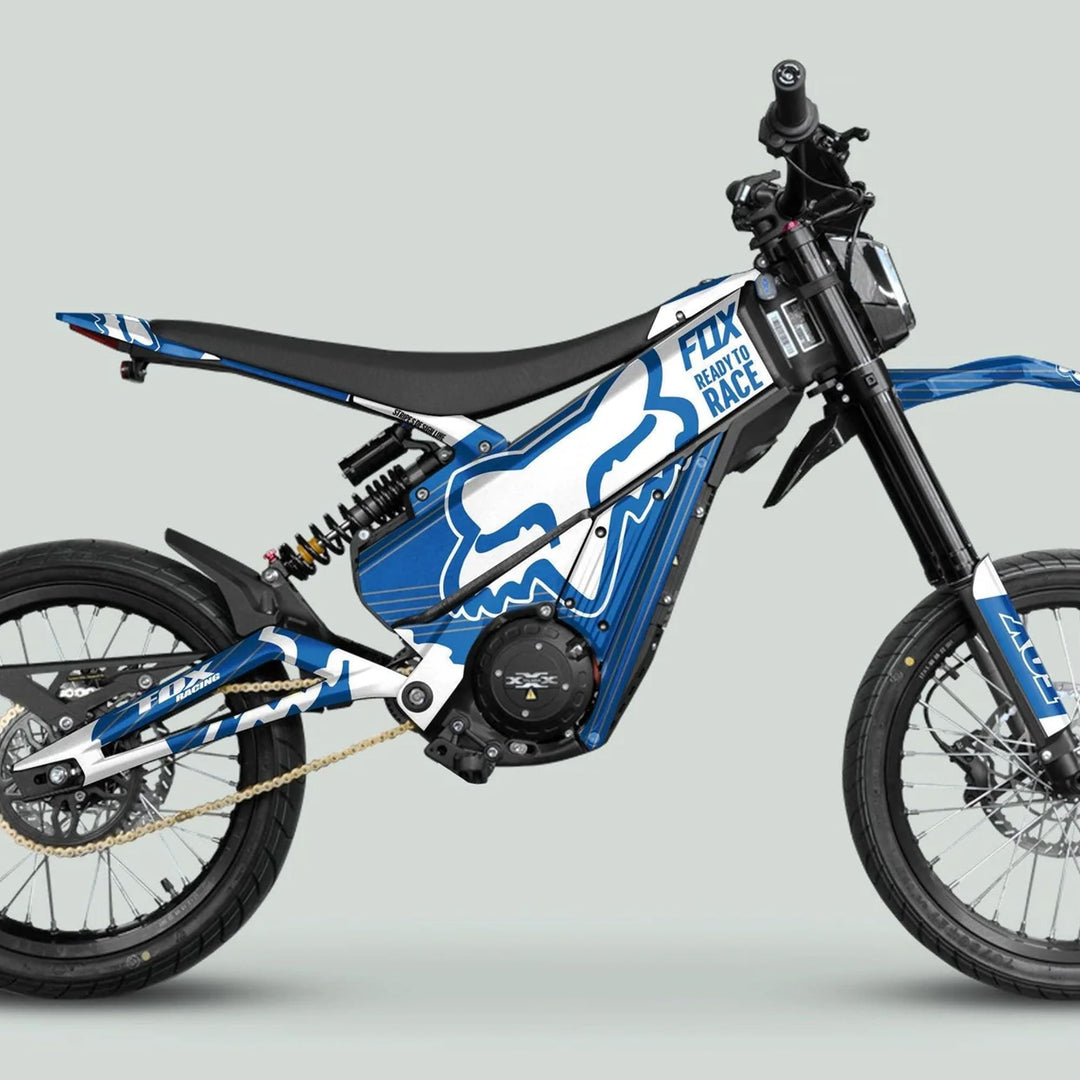 Talaria XXX Graphics Kit FOX STRIPES Blue White on an electric off-road motorcycle, featuring spoked wheels and suspension, showcasing vibrant, durable vinyl design for style and protection.