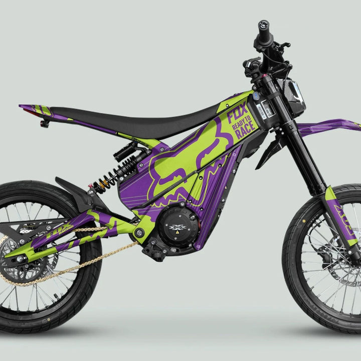 Talaria XXX Graphics Kit FOX STRIPES Purple Green on an electric dirt bike, featuring high-rise handlebars, knobby tires, chain drive, and full frame coverage.