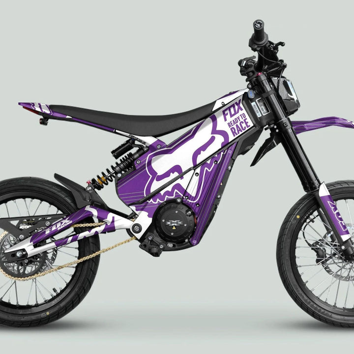 Talaria XXX Graphics Kit FOX STRIPES Purple White on a motocross-style motorcycle with knobby tires, single-sided swingarm, and Fox Racing graphics.