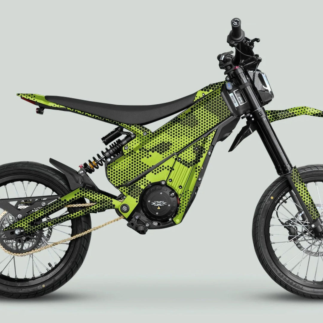 Side-view of a Talaria e-dirt bike with HEXOCAM Green graphics, featuring a high-torque electric motor, knobby tires, and angular green-black honeycomb frame.
