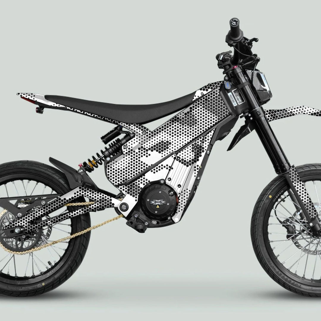 Side view of an electric dirt bike featuring the Talaria XXX Graphics Kit HEXOCAM White with honeycomb pattern, enhancing style and protection.